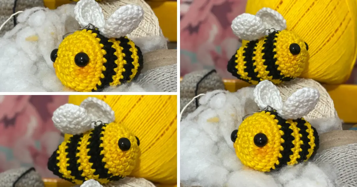 Fotografia de dois chaveiros de abelha feitos em crochê estilo amigurumi. As abelhinhas são amarelas com listras pretas, asas brancas e olhos grandes e pretos. Elas estão com um leve blush rosado nas bochechas, transmitindo delicadeza e charme. Ao fundo, há novelos de lã nas cores amarela, creme e cinza, com uma parede floral desfocada, compondo uma cena aconchegante e artesanal.