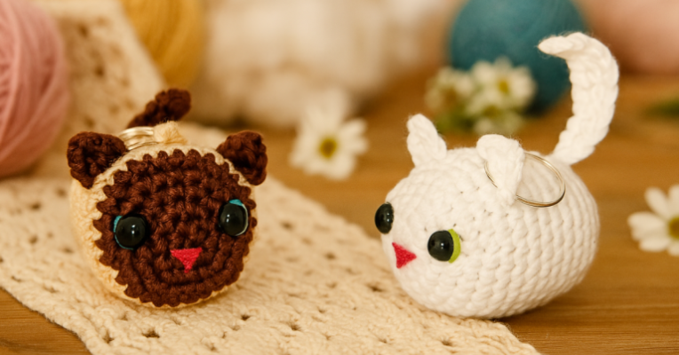 Gato Chaveiro de Crochê – Receita Amigurumi Passo a Passo: chaveiros de crochê em formato de gatinho, feitos com técnica amigurumi, nas cores marrom com bege e branco, sobre mesa de madeira com fundo decorativo de flores secas e novelos – ideal para quem busca passo a passo criativo e delicado.Gato Chaveiro de Crochê – Receita Amigurumi Passo a Passo: chaveiros de crochê em formato de gatinho, feitos com técnica amigurumi, nas cores marrom com bege e branco, sobre mesa de madeira com fundo decorativo de flores secas e novelos – ideal para quem busca passo a passo criativo e delicado.