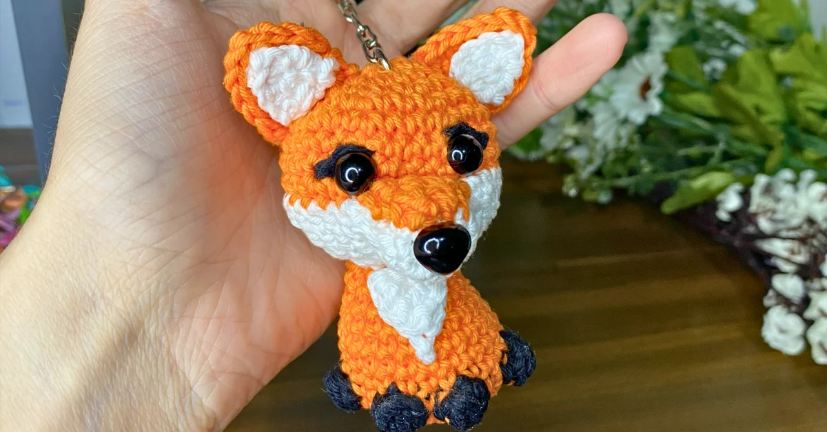 Chaveiro Raposa Amigurumi de Crochê feito à mão – peça artesanal com fios de algodão nas cores laranja, branco e preto. Receita grátis passo a passo para criar um chaveiro fofo de raposa em amigurumi, ideal para iniciantes e para presentear.